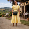 Leather Shoulder Bag worn by a woman in a yellow dress, showcasing its elegant design against a scenic outdoor backdrop.