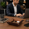 Large Leather Desk Tidy Tray on a desk, organizing keys and essentials while a man works on a laptop.