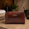 Leather Toiletry Bag made from premium Italian leather with antique brass hardware on a countertop.