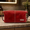 Mens Leather Wash Bag in rich red leather on a countertop with stylish decor.