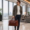 Stylish man in airport holding Leather Travel Bag, a perfect Leather Travel Bag for elegant travel.