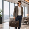 Man in a stylish outfit carrying a Leather Travel Bag at an airport.