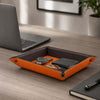 Leather Valet Tray featuring vibrant orange leather, holding a watch, wallet, and keys on a modern desk.