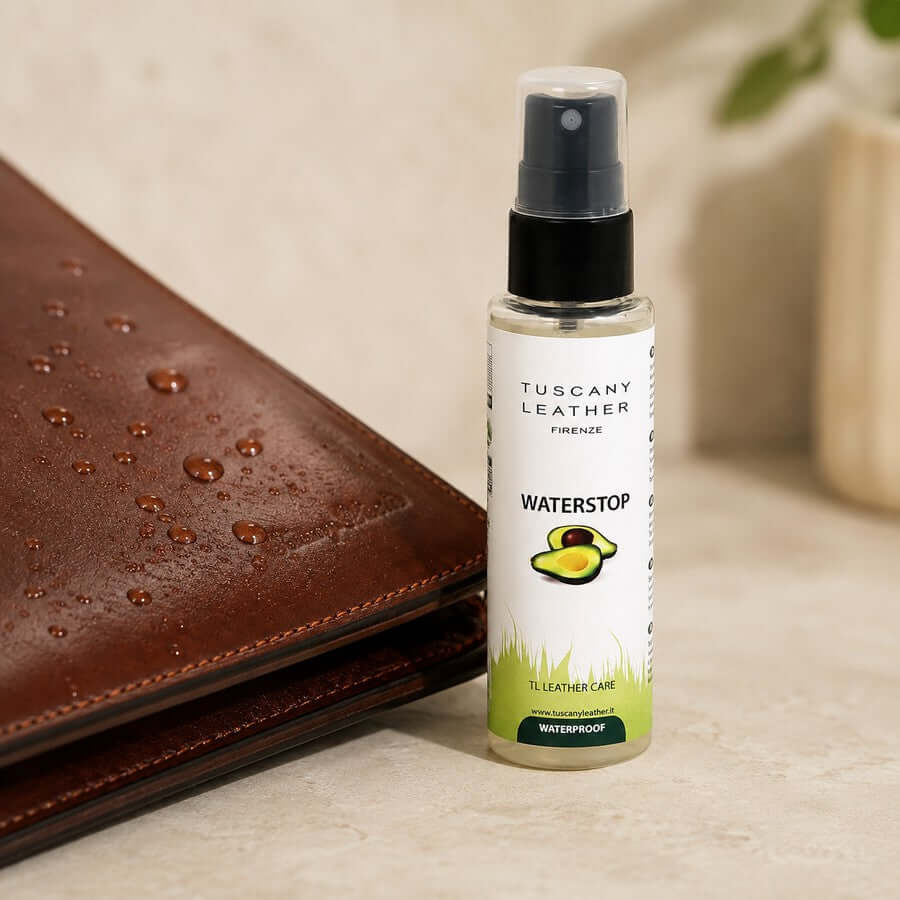Leather waterproofing spray beside a brown leather bag with water droplets