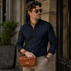 Stylish man wearing sunglasses with Leather Mens Wrist Bag, showcasing elegance and functionality.