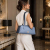 Luxury Leather Shoulder Bag in a stylish setting, held by a woman wearing a white outfit.