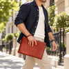 Man Walking And Holding The Brown Mens Italian Leather Clutch Bag