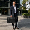 Mens Leather Messenger Bag being carried by a man in a suit in an urban setting.
