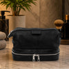 Mens Toiletry Bag Leather in sleek black leather, featuring a large zip pocket and double bottom, ideal for all toiletries.