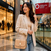 Woman smiling and carrying a Leather Over Shoulder Bag in a shopping center.