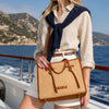 Raffia Shoulder Bag showcased on a woman in a stylish nautical setting, highlighting its natural texture and elegant design.