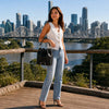 Model wearing a stylish Leather Bucket Bag with a view of the city skyline in the background.