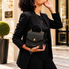 Stylish woman holding a Small Leather Shoulder Bag, showcasing elegance.