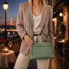 Small Tote Bag in mint green held by a woman wearing a blazer, set in a romantic outdoor dining scene.