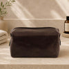 Leather Wash Bag made from premium Italian leather displayed on a countertop next to toiletries.