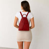 Woman wearing a red Luxury Leather Backpack, showcasing its stylish design and adjustable shoulder straps.