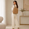 Woman wearing a Soft Leather Backpack in a stylish outfit, showcasing elegance and practicality.