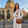 Woman wearing a stylish cream sweater and holding a Leather Fringe Bag in front of a historical building in Bendigo.