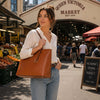 Woman carrying a Soft Leather Shopper Bag at Queen Victoria Market, showcasing style and functionality.