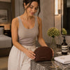 Woman Placing The Dark Brown Soft Leather Toiletry Case On A Bathroom Sink