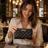 Woman holding Soft Leather Wallet in a stylish restaurant setting, showcasing its luxurious design.