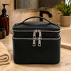 Travel Toiletry Bag in black leather with dual zippers on a bathroom counter.