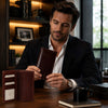 Man examining the Leather Vertical Bifold Wallet in a stylish office setting.