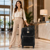 Stylish woman with 4 Wheeled Luggage in hotel lobby, showcasing its elegance and functionality.