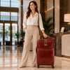 Woman in a hotel lobby with 4 Wheeled Luggage, showcasing stylish travel essentials.
