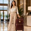Stylish woman with 4 Wheeled Luggage in hotel lobby, ready for travel.