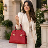 Stylish woman in a cream suit holding a lipstick red Womens Leather Handbag outdoors, exuding elegance and charm.