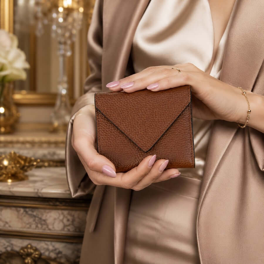 Woman holding a cognac leather wallet selected as a thoughtful birthday gift