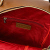 Interior view of the Leather Backpack featuring red lining and zippered pocket, showcasing Leather Backpack and Toiletry Bag Set.
