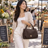 Woman Walking Through A Market Carrying The Chocolate Womens Bag