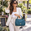 Woman Walking Past A Flower Shop Carrying The Teal Womens Bag