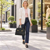 Woman walking in a city with Womens Leather Handbag, wearing stylish blazer and jeans.