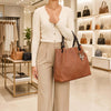 Woman holding a Woven Leather Bag in a stylish retail store, showcasing its elegant design and texture.