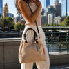 Woman holding a Woven Leather Bag by the waterfront in Melbourne.